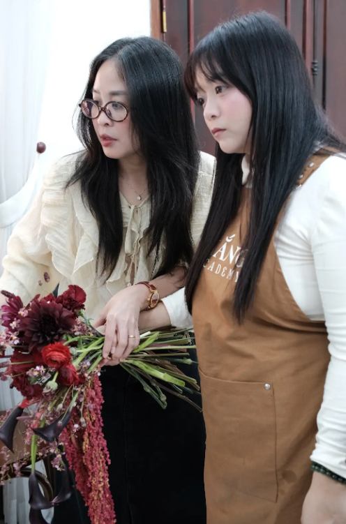 Học viên thực hành bó hoa cùng trợ giảng trong lớp offline Nắng Academy